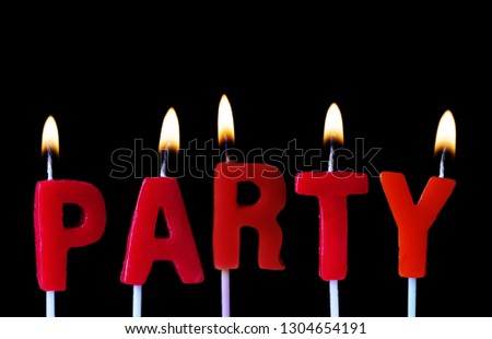 Party spellt out in red birthday candles against a black background