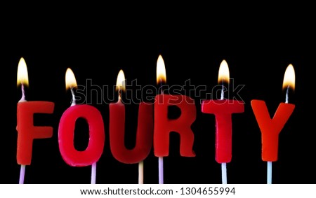 Fourty spellt out in red birthday candles against a black background