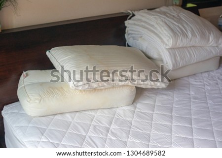Dirty pillows on white beds are a source of germs and dust mites and mattresses.Photo with noise. Closeup