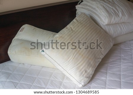 Dirty pillows on white beds are a source of germs and dust mites and mattresses.Photo with noise. Closeup