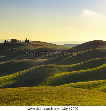 Tuscany, rural landscape in Crete Senesi land. Rolling hills, countryside farm, cypresses trees, green field on warm sunset. Siena, Italy, Europe. Royalty-Free Stock Photo #130469090