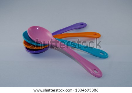 Multicolored little plastic spoons on a black background