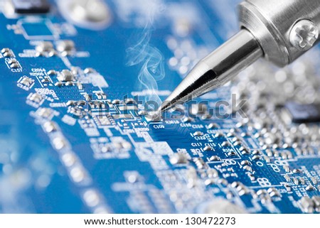 Microcircuit being fixed with soldering iron - very sharp micro photo Royalty-Free Stock Photo #130472273
