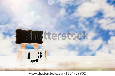 Calendar box with blackboard for entering text,April 13 days Place on wooden table,bright blue sky background, copy space and in put text,decoration website or wallpaper