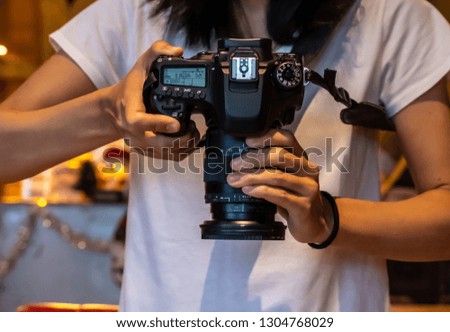 Closeup view hand holding digital camera, top view of man hand holding digital camera.