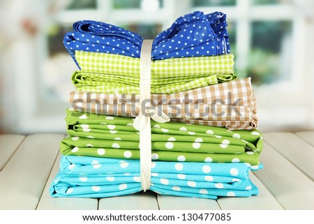 Color mottled fabrics on wooden table on window background