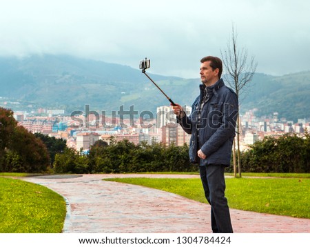 adult man with casual style  making selfie in a park in  Bilbao city.Spain