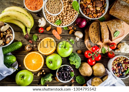 Healthy food. Selection of good carbohydrate sources, high fiber rich food. Low glycemic index diet. Fresh vegetables, fruits, cereals, legumes, nuts, greens. Wooden background copy space Royalty-Free Stock Photo #1304795542