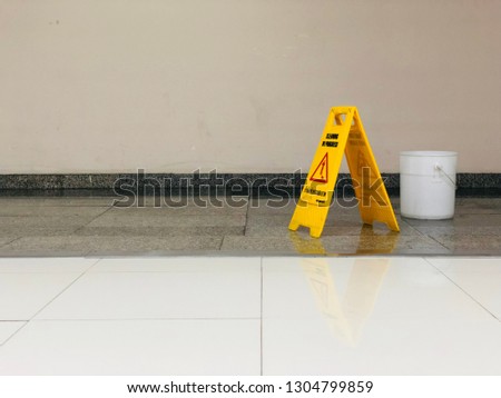 the safety first yellow floor cautioned signage has a phrase as caution of wet floor and cleaning in the progress , please be careful otherwise will slip on the floor