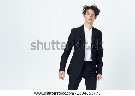 Cute curly man in a suit on a light background office worker