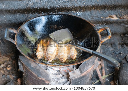 Fried fish on dirty Frying Pans.