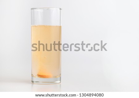 Orange effervescent bubbles of vitamin C in transparent glass
