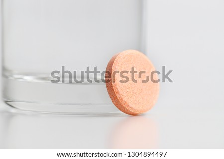Orange effervescent vitamin C and a transparent glass with water