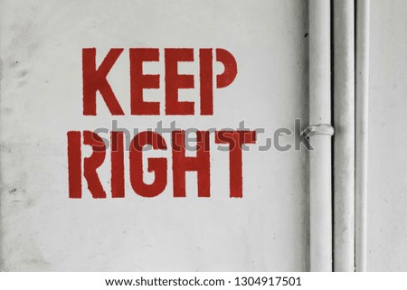 White painted wall with a KEEP RIGHT signage in red color