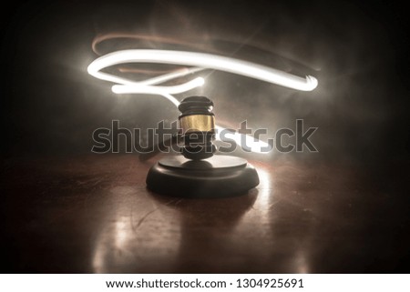 Law theme, mallet of the judge on wooden desk with Lady Justice Statue. Law gavel on dark foggy background with light. Selective focus