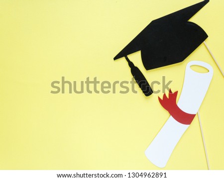 Creative background with photobooth props for graduation: hats, diploma, glasses, lips on bright yellow paper background. Education, study concept. 