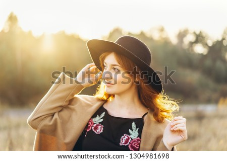 Pretty and happy red hair girl walking in the field