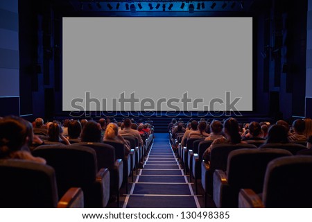 Empty cinema screen with audience. Ready for adding your picture. Screen has crisp borders. This shot was made using tripod with long exposure. Royalty-Free Stock Photo #130498385