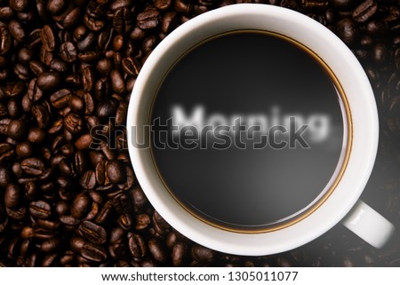Cup of coffee with morning smoke and coffee beans on table with coffee beans.