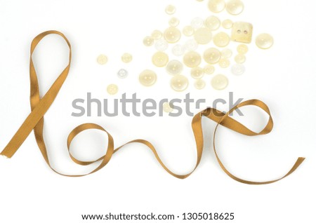 Word LOVE written with gift  packing tape and plastic buttons on white background