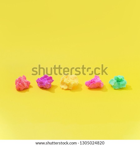 Colorful slime on bright yellow background. Minimal creative art concept.