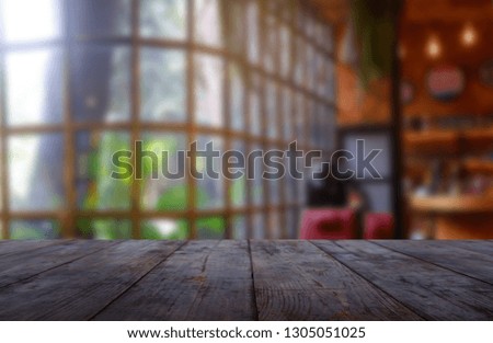 Empty wooden table in front of abstract blurred background of restaurant, cafe and coffee shop interior. 