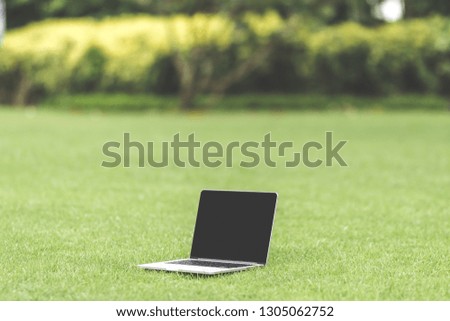 Mockup of modern laptop with black screen in the green tropical park of Bali island.