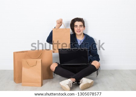young with computer and shopping bags, online purchases