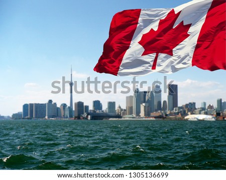  TORONTO, CANADA - Canadian flag is waving front of Toronto City view