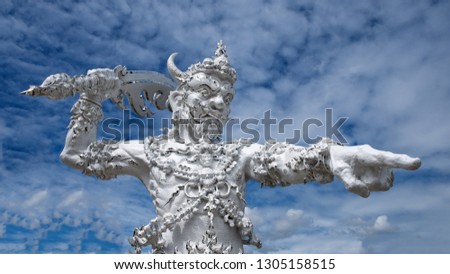 Pointing warrior or bhuddistic figure in front of the White Temple of Wat Rong Khun, Chiang Rai, Thailand