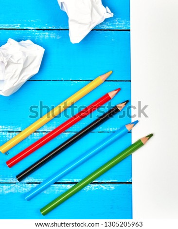 multicolored wooden pencils on blue background, top view