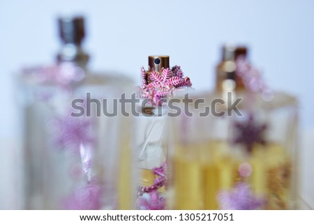Spray bottles of perfume on a light background. Beauty industry. The picture in bright colors. Shallow depth of field                               
