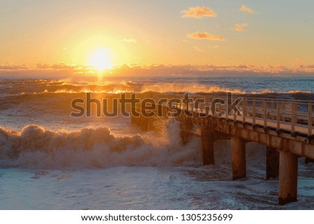 Yellow sun lights big storm waves. Sunset on the sea. Beautiful nature
