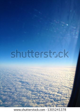 Clouds and sky as seen through window of an aircraft.