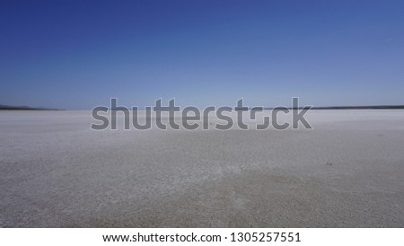 Coast of Salt Lake (Tuz Golu), Turkey. Breathtaking lake landscape under clear sky. White sand and amazing blue unique lake on sunny day. Dry lake / land in Asia. Global warming effect concept photo.
