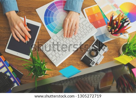 Young cute Graphic designer using graphics tablet to do his work at desk view from above