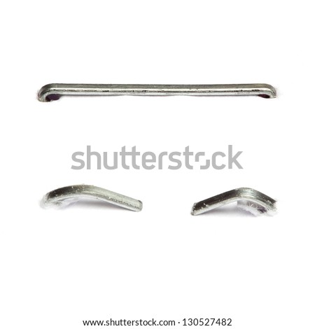 Set of different staples pushed into a piece of paper. Isolated on white background. Royalty-Free Stock Photo #130527482