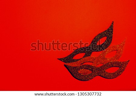 Carnival symbol on a red background. The sparkling carnival mask. Carnival poster. Place for text. A party. Party invitation. Multicolored glitter. Photo booth.