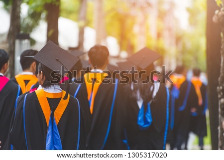 Education theme concept. Back view of Graduates during commencement.
