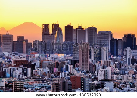 Tokyo, Japan cityscape with Shinjuku Ward and Mt. Fuji in the distance at dusk.