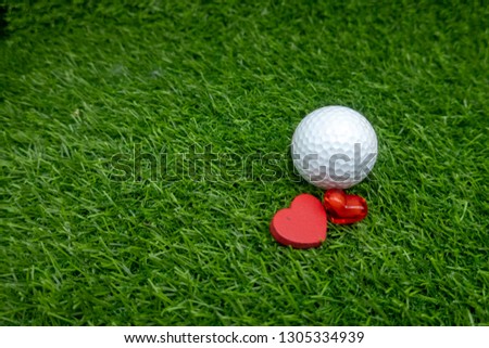 A golf ball with a love red heart on green grass is a image of love, care, and appreciation. It could be given as a gift to show how much somebody cares for you, or it could be placed in a special spo