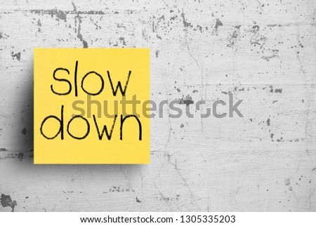 Sticky note on concrete wall, Slow down
