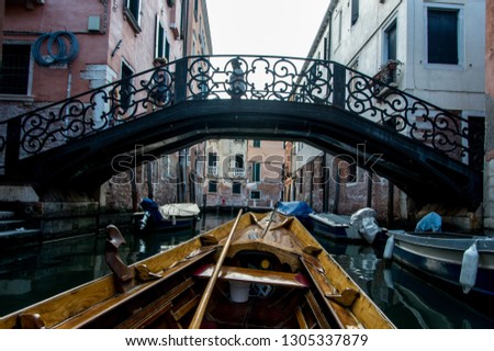 Inside of a classic Italian Gondola Boat. Shot in Venice Italy during the summertime. Picture includes a bridge, boat, water, buildings, and beautiful canals