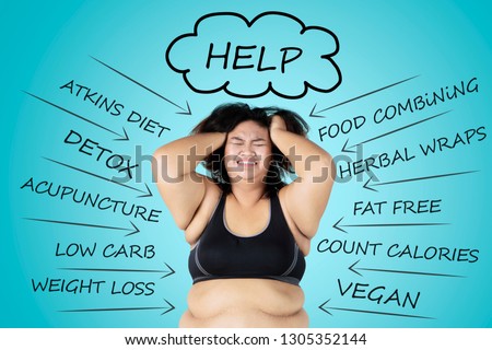 Picture of depressed fat woman scratching her head while thinking her problems in the studio