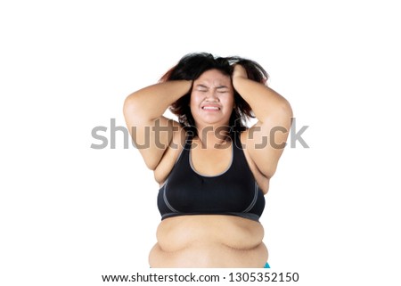 Picture of depressed fat woman wearing sportswear while scratching her head, isolated white background