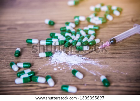 Assorted pharmaceutical medicine pills, tablets and capsules over wooden background.select focus.