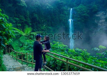 Picture of young man vacating with his daughter in the Pelangi waterfall at Bandung, Indonesia
