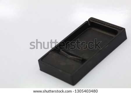 The black Japanese ink pot isolated on the white background, in concept of arts, drawing, letter.