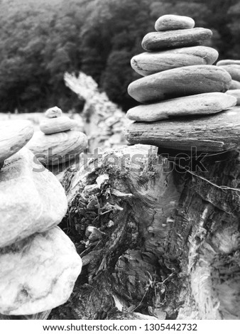 Black and white photography of stone stacking at the edge of a river.
