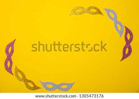 Carnival symbol on a yellow background. The sparkling carnival mask. Carnival poster. Place for text. A party. Party invitation. Multicolored glitter. Photo booth.